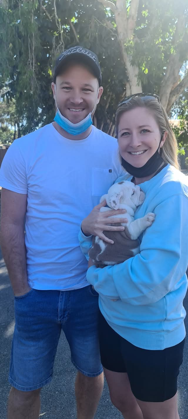 Happy couple with new bulldog puppy