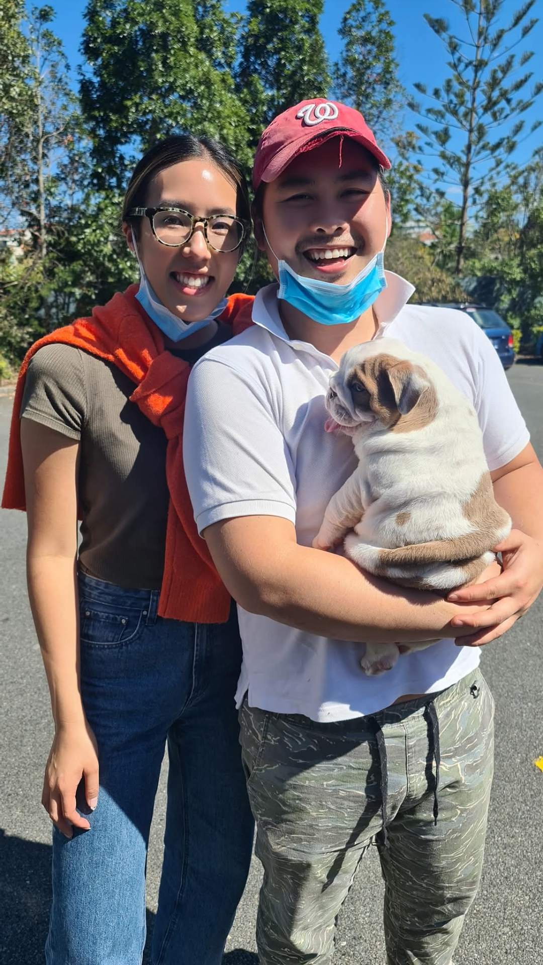 Couple picking up their bulldog puppy